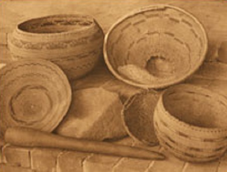 West coast of
                the "USA": Pomo natives with baskets, mortar,
                and pestle.